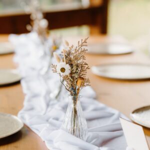 Decor de masă alcătuit din văzuțe din sticlă cu flori uscate – rustic